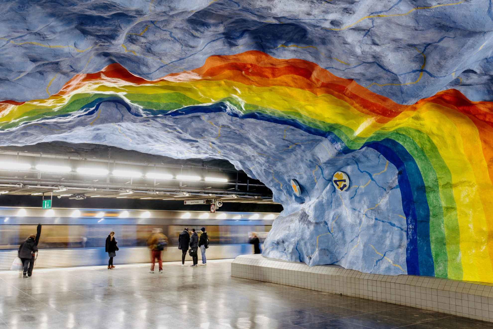 Un arc-en-ciel aux couleurs vives peint au plafond d'une station de métro.