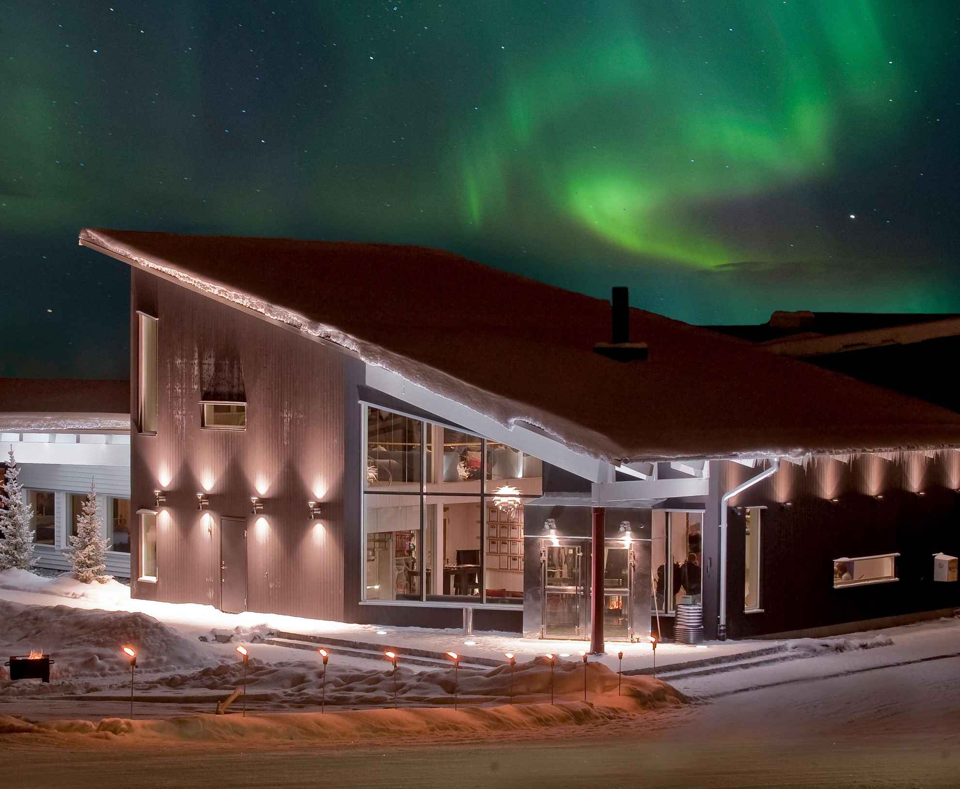 L'aurore boréale se trouve dans le ciel au-dessus d'une maison pendant la nuit en hiver.