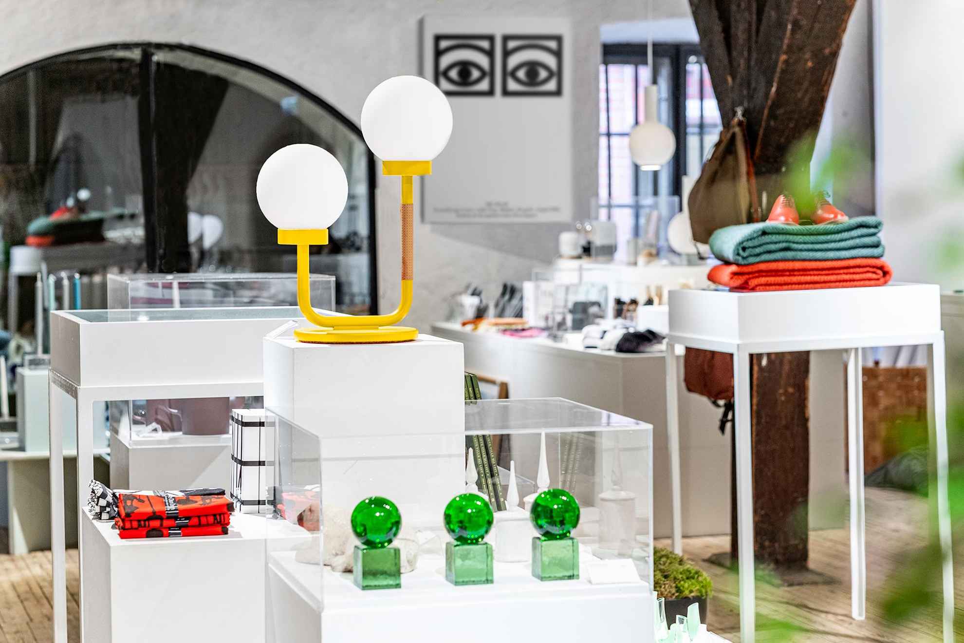 La boutique du centre Form/Design. De nombreux objets de design sont exposés, tels que des lampes, des objets d'art en verre et d'autres articles.