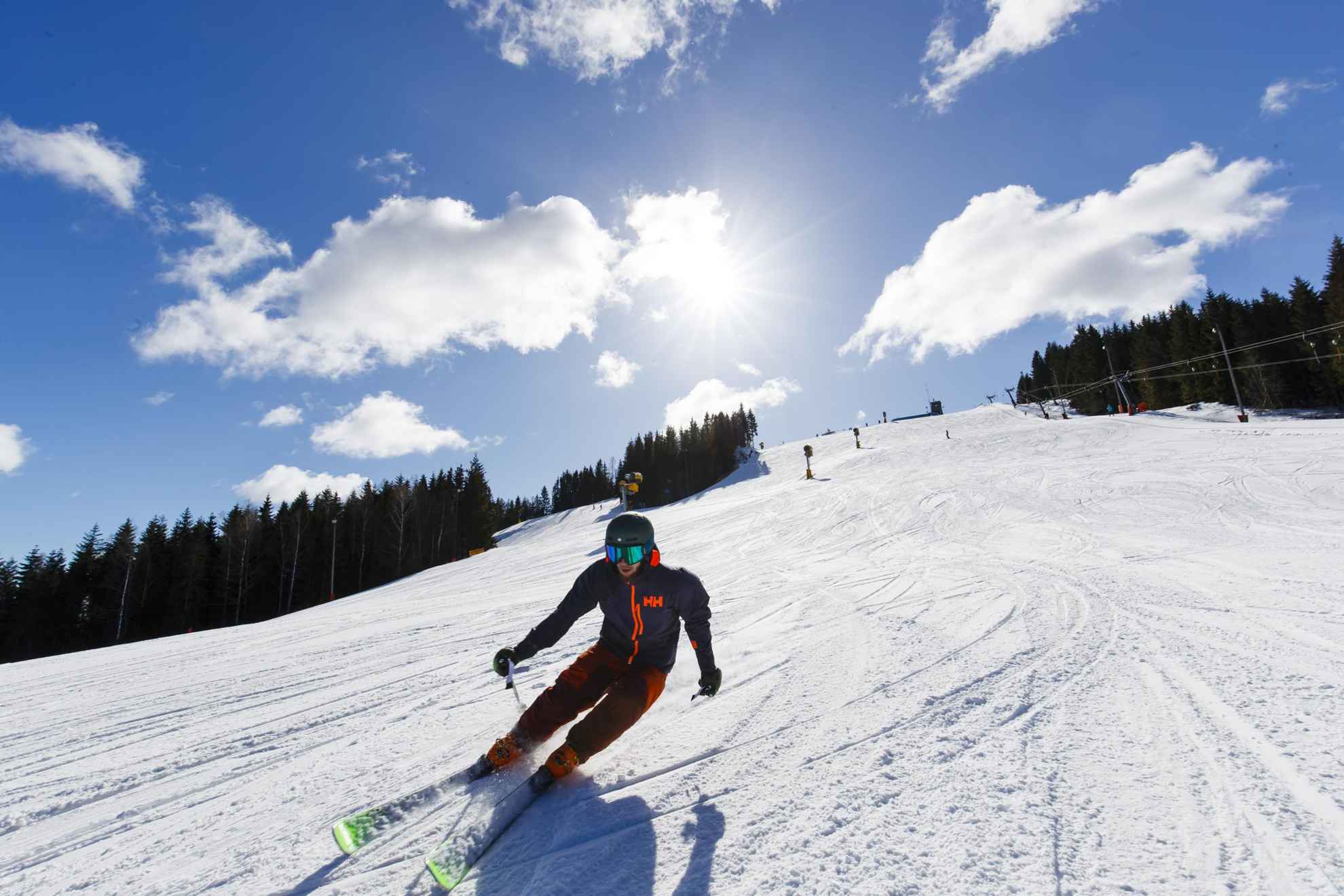 Une personne faisant du ski alpin par une journée d'hiver ensoleillée.