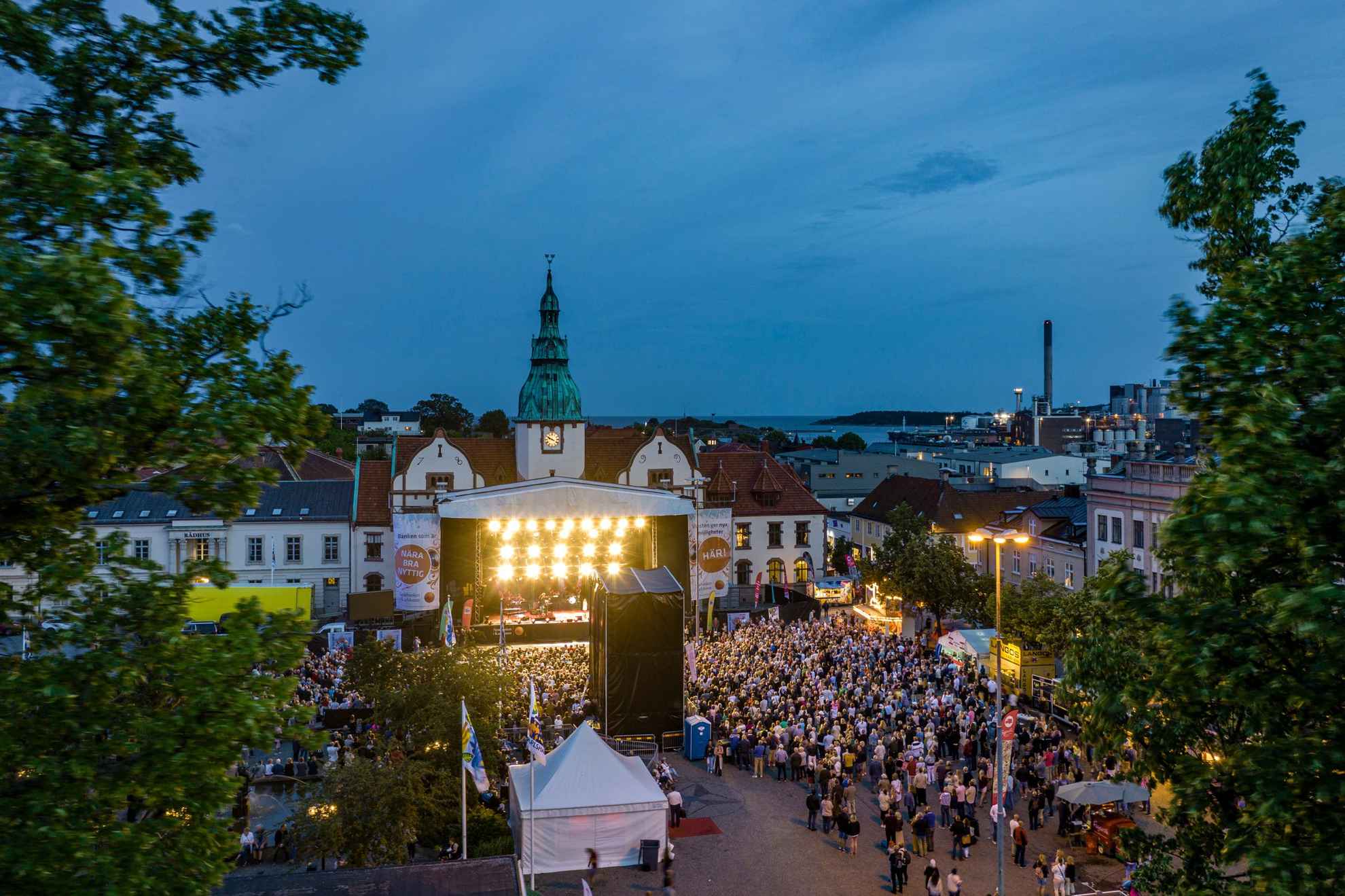 Un festival dans une petite ville avec un concert populaire en soirée.