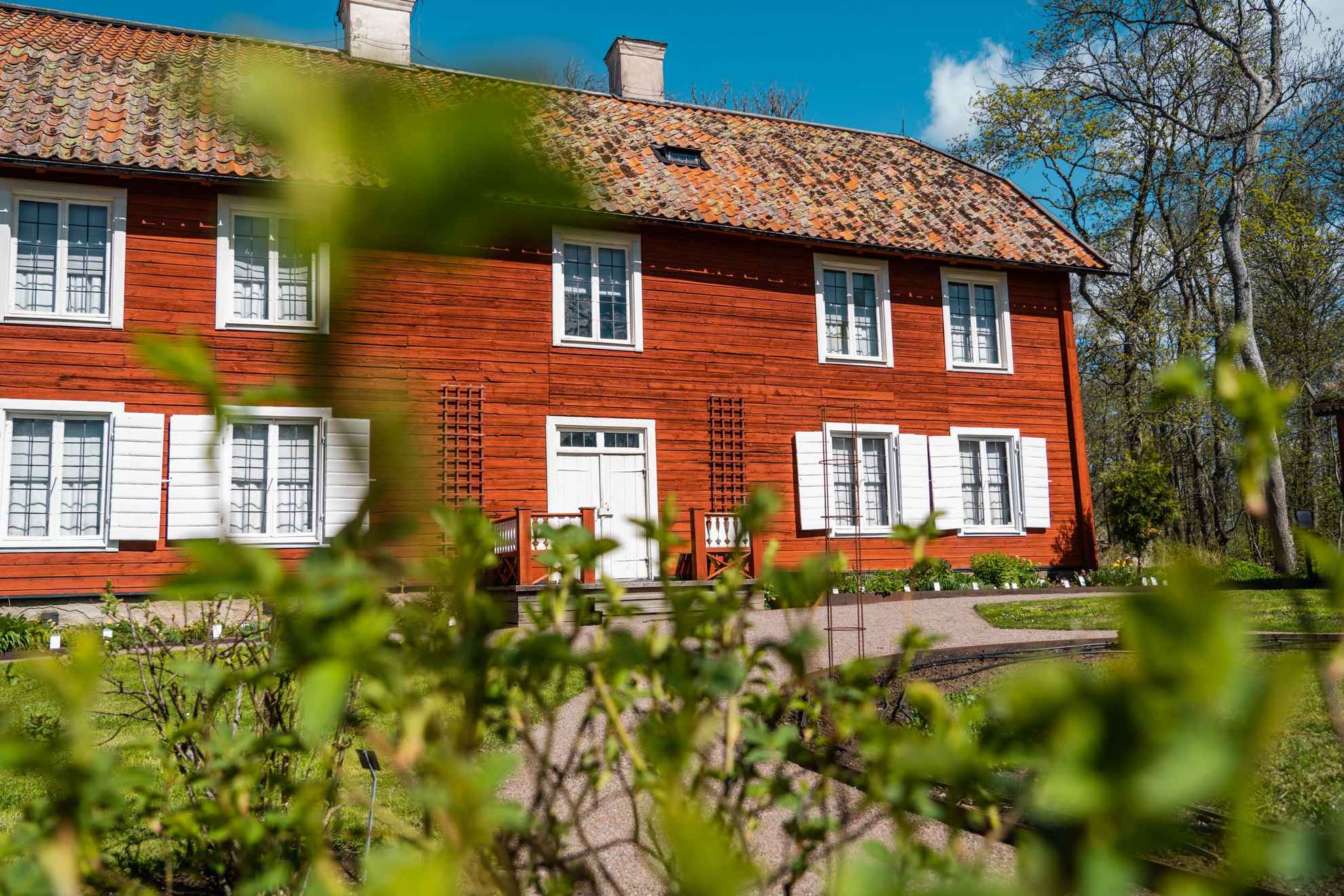 Une vieille maison en bois rouge avec un toit en tuiles.