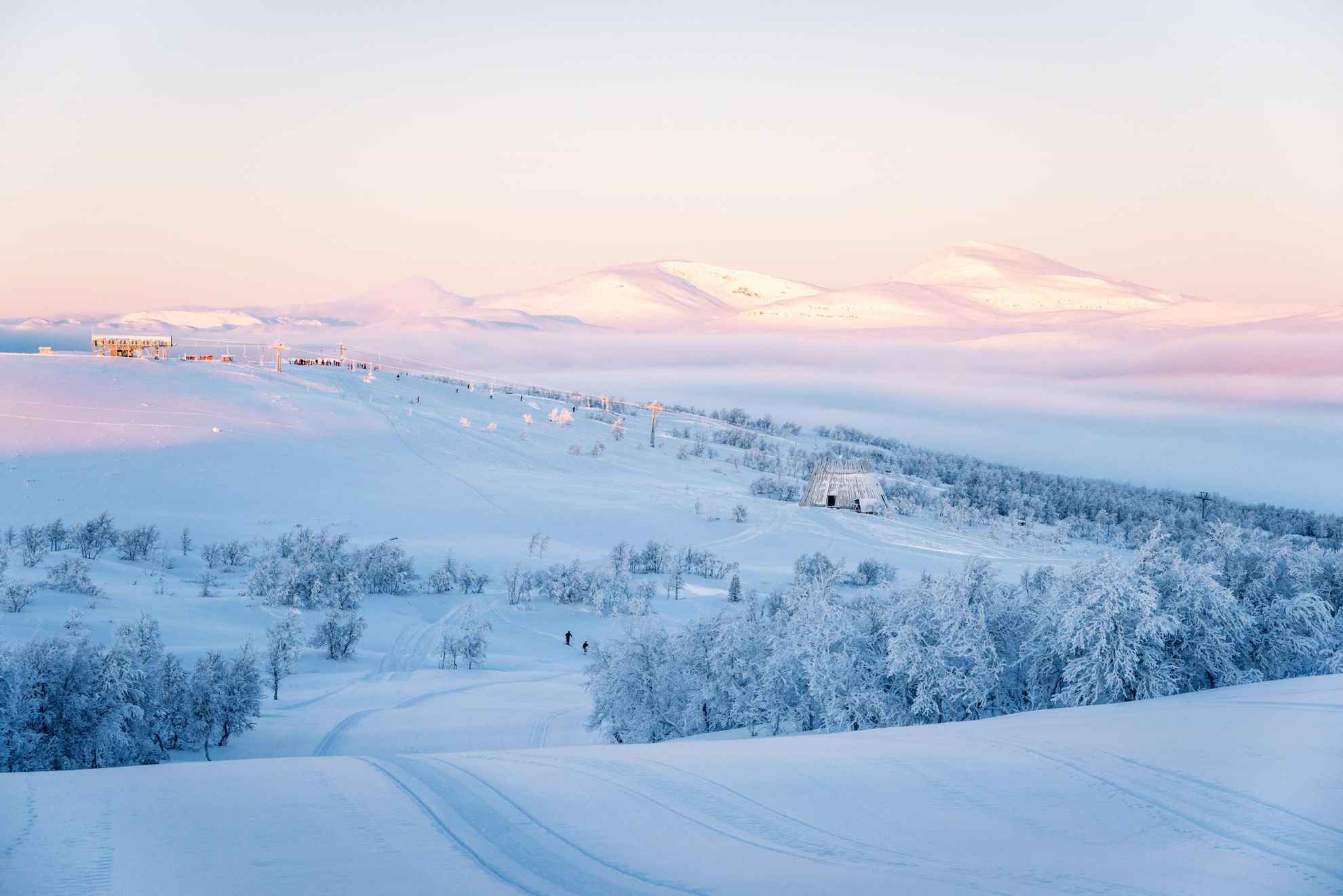 Vue sur une région enneigée et une piste de ski de fond avec Ramundberget en arrière-plan.
