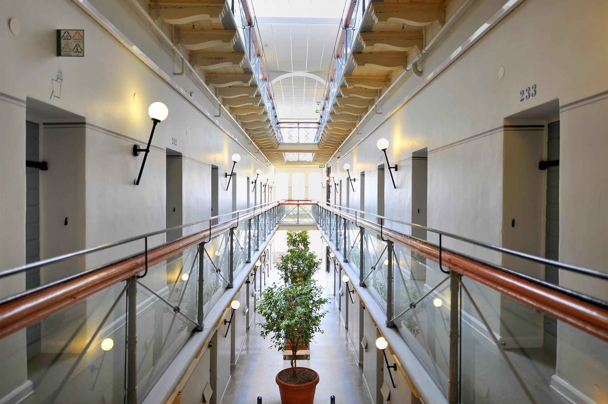 Un long couloir avec de chaque côté des portes. La photo a été prise dans la STF Långholmen Hostel, une ancienne prison située à Stockholm