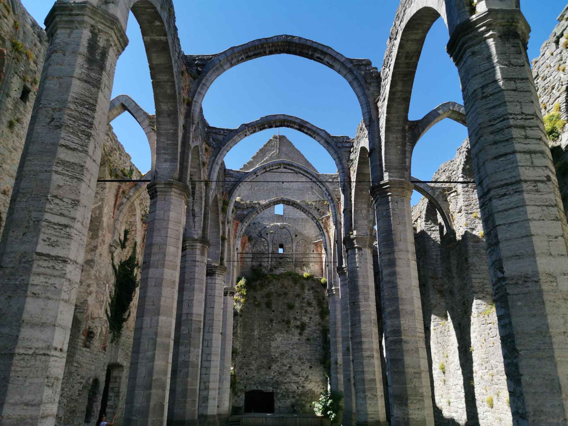 Vue depuis l'intérieur d'une église en ruine avec de hautes voûtes sans toit.