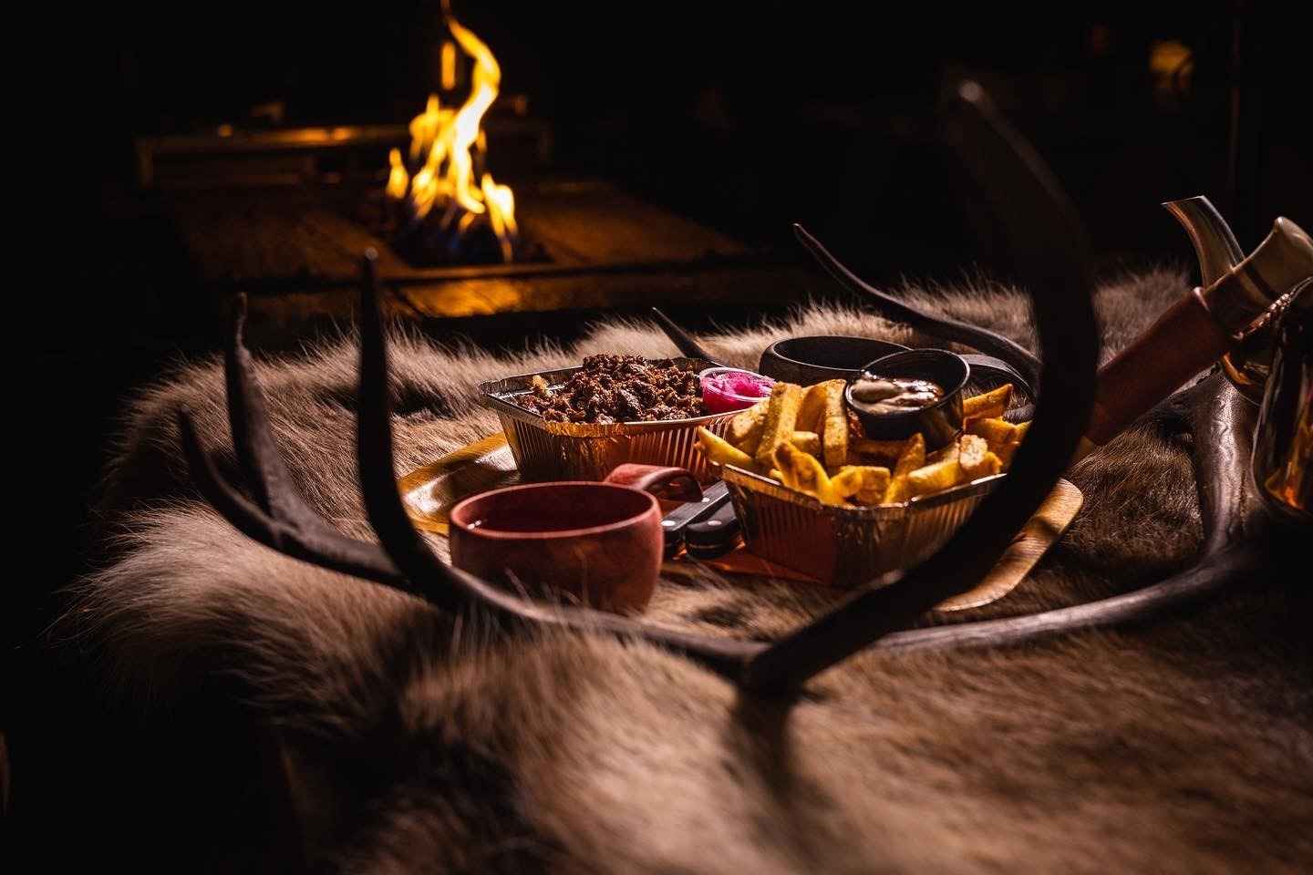 Les repas sont servis devant un feu de cheminée dans un lavvu.