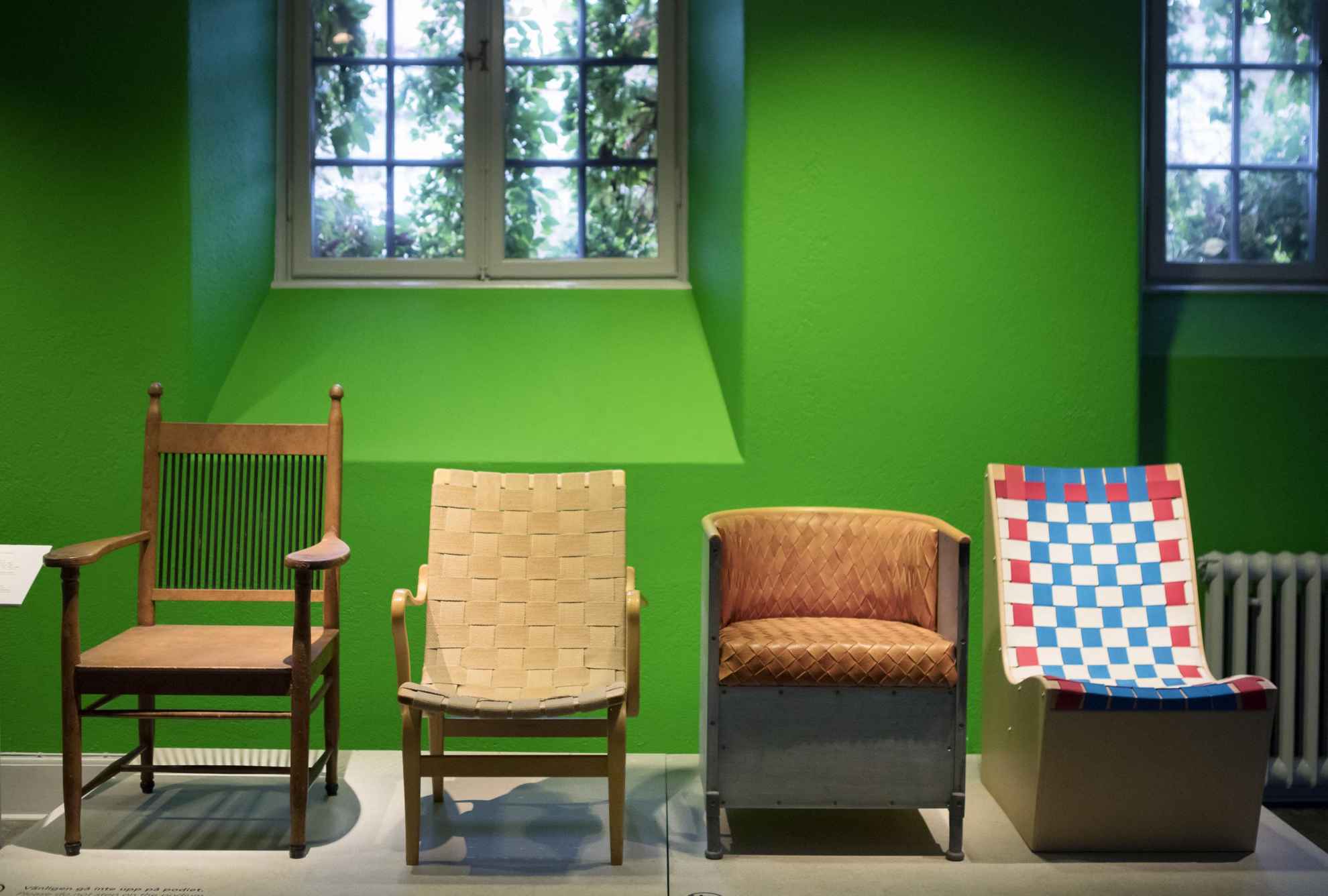 Une exposition présentant quatre chaises différentes dans un musée.