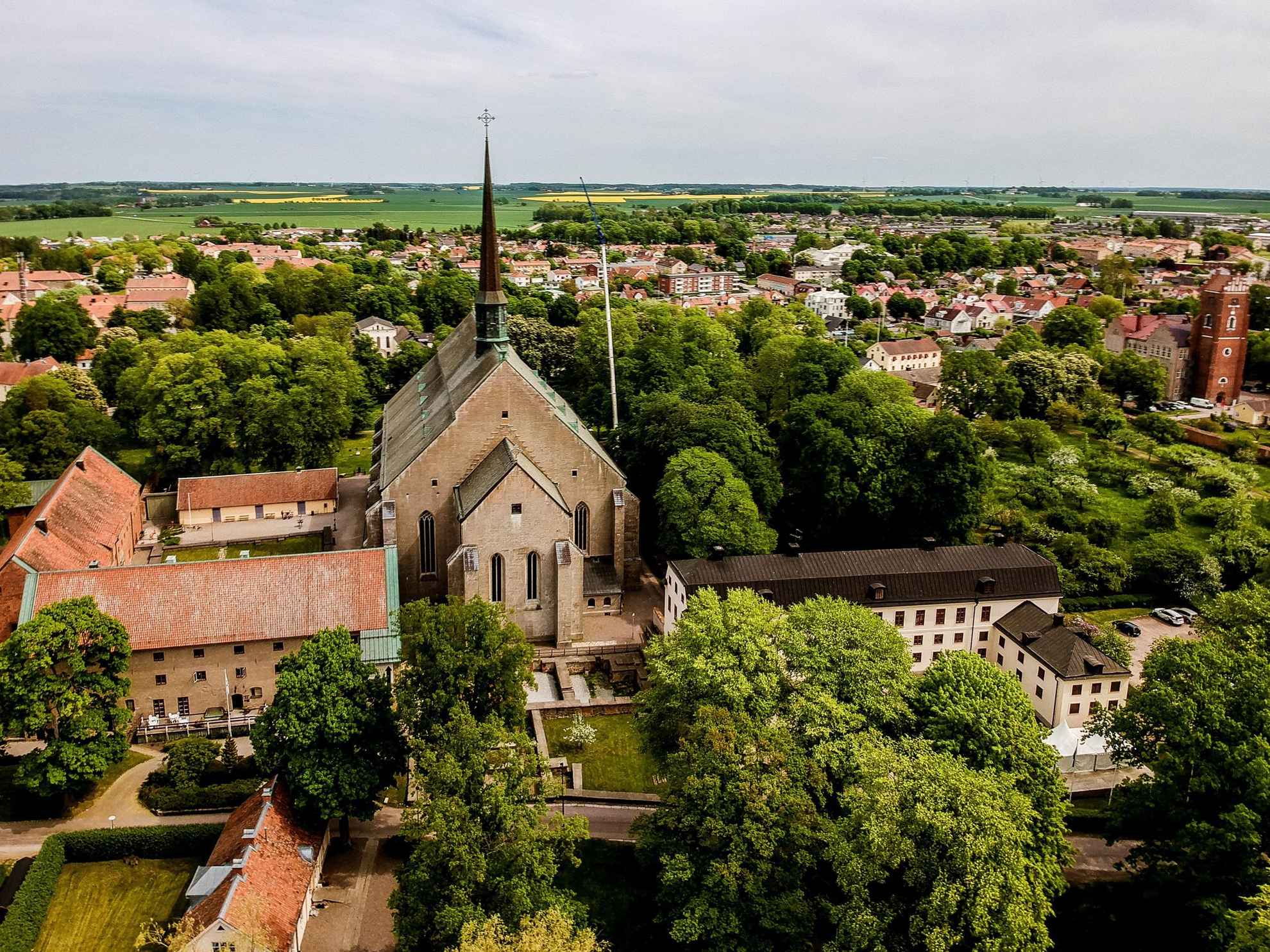 Photo aérienne estivale du monastère de Vadstena entouré de verdure.