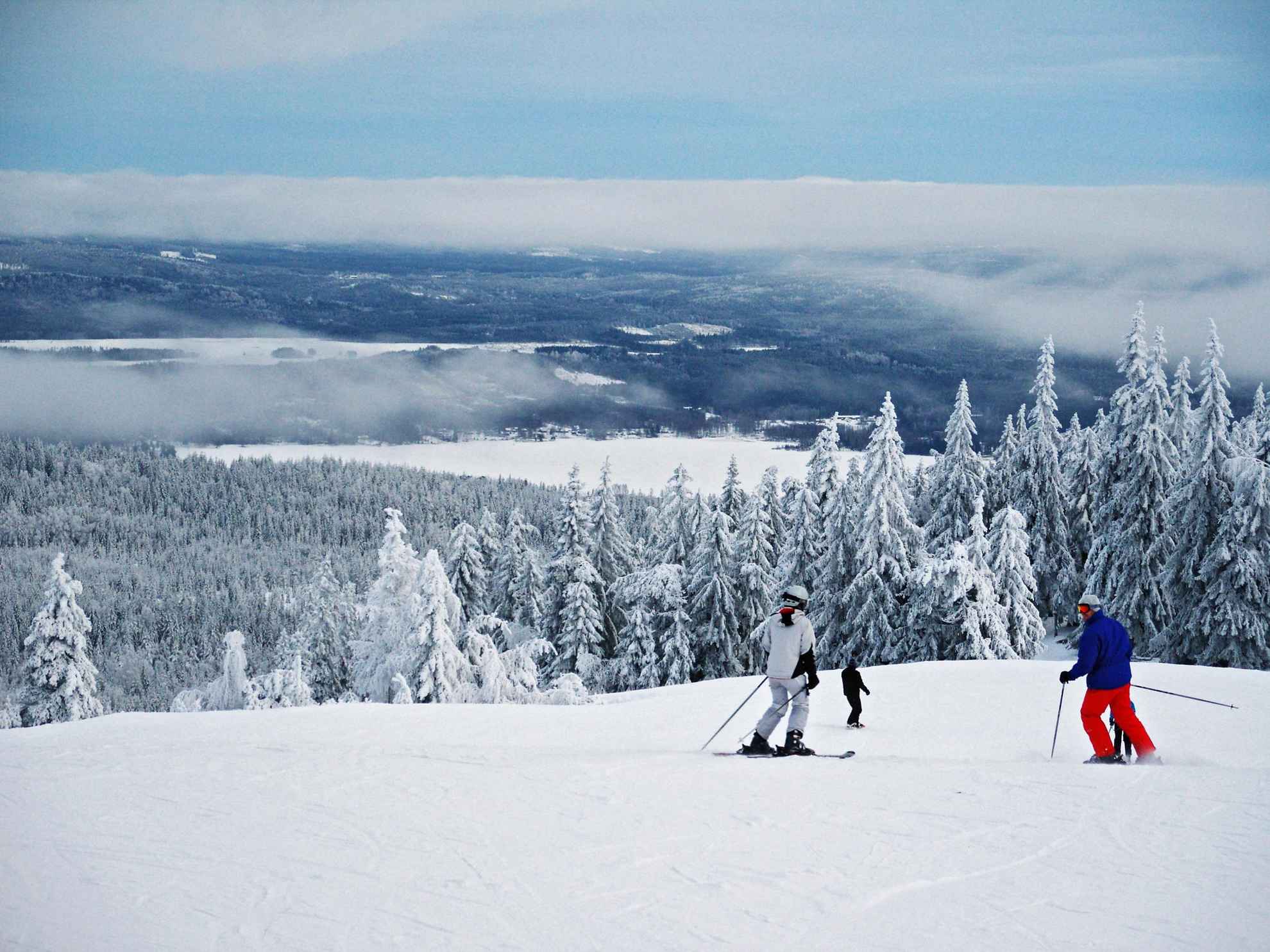 Une vue de la montagne enneigée. Les gens descendent la piste de ski.