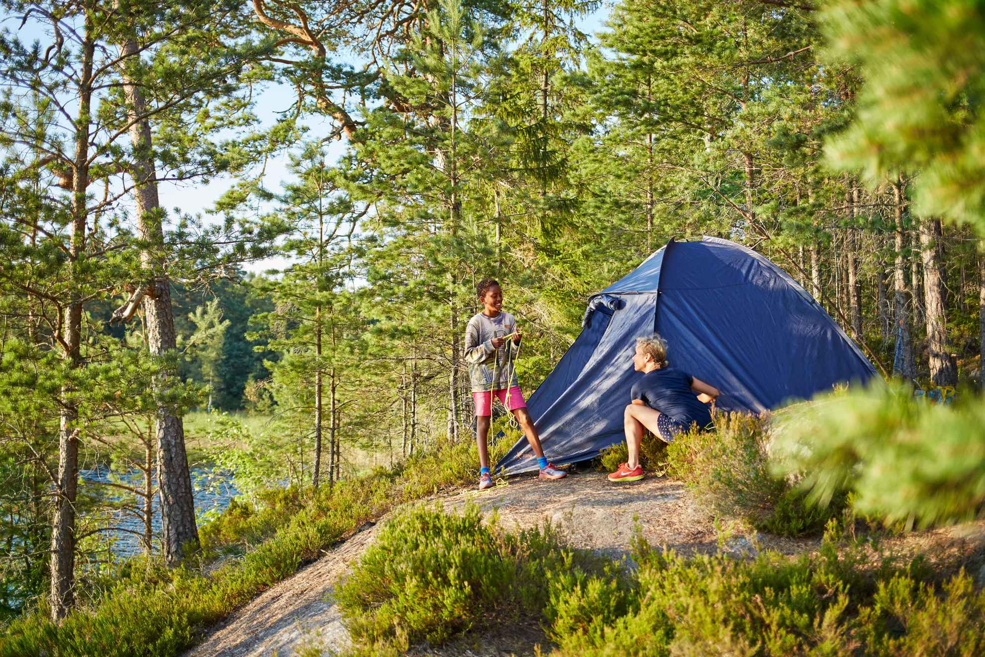 Deux personnes se trouvent dans une tente en Suède, dans les bois, près d'un lac.