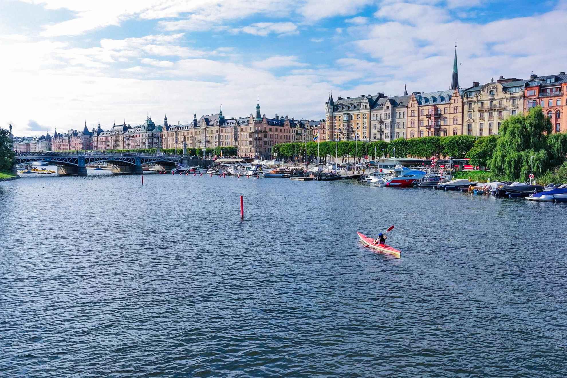 Une femme fait du kayak dans le centre ville de Stockholm par une belle journée d'été.
