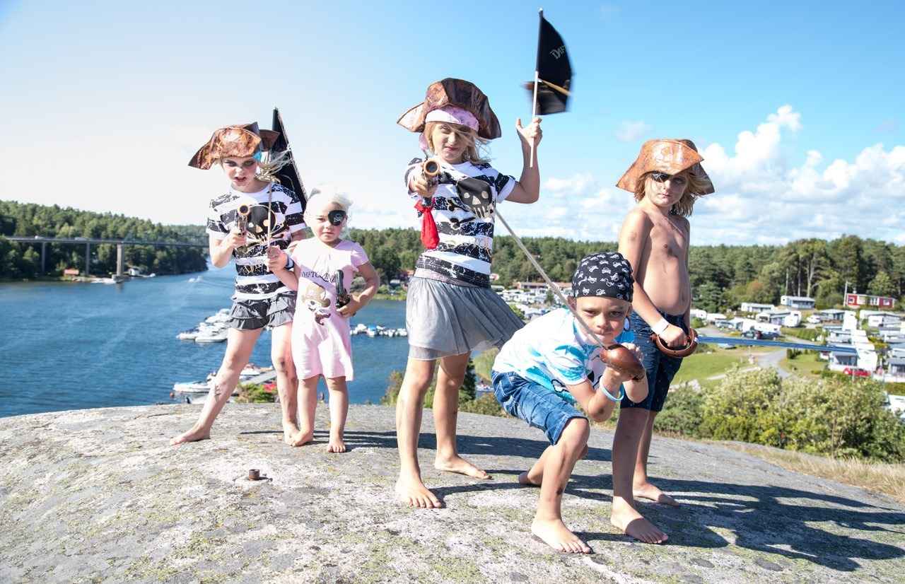 Cinq enfants déguisés en pirates posent devant l'appareil photo.