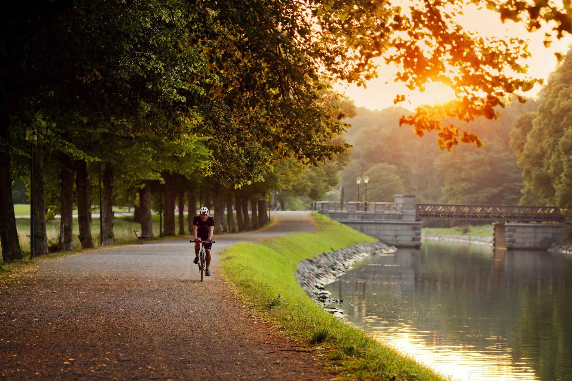 A man is on a morning bike ride along the water canal in Djurgården city park in Stockholm.