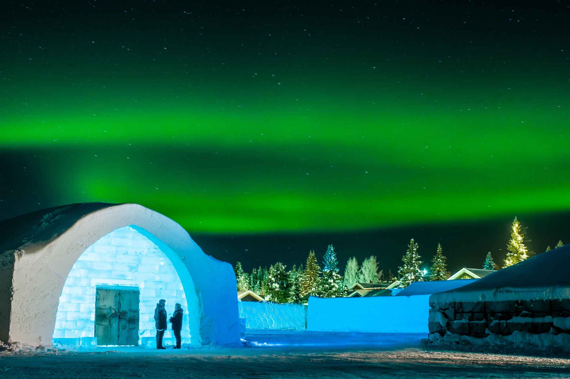 Une aurore boréale verte brille au-dessus de l'entrée de l'Icehotel.