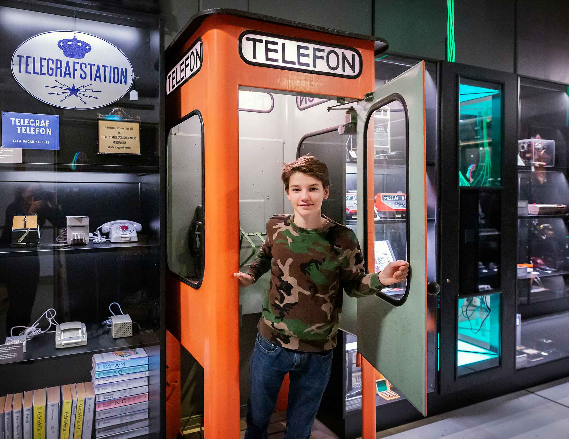 Un garçon est en train de sortir d'une cabine téléphonique au Musée national des sciences et de la technologie.