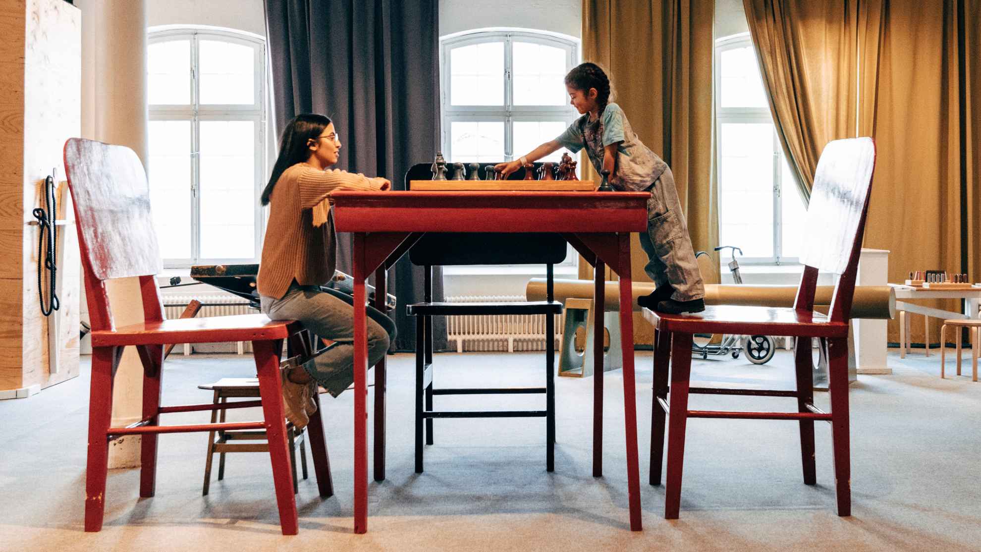 Une femme et un enfant jouent aux échecs sur une grande table à Tom Tits
