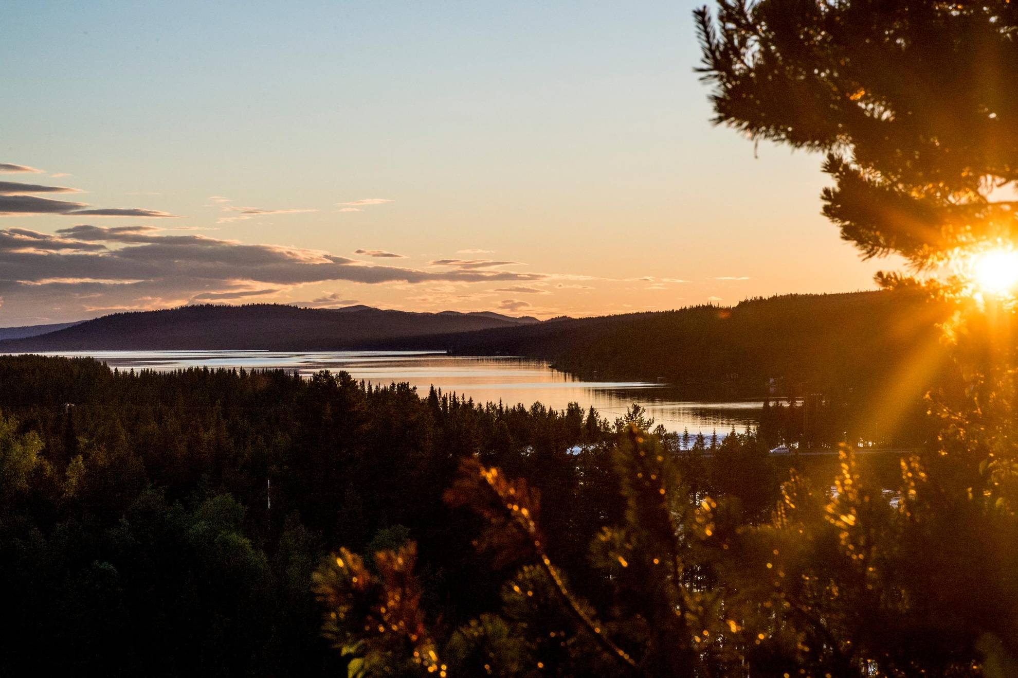 The Midnight Sun over a lake and forest in the Swedish Lapland. The mountains in the background.