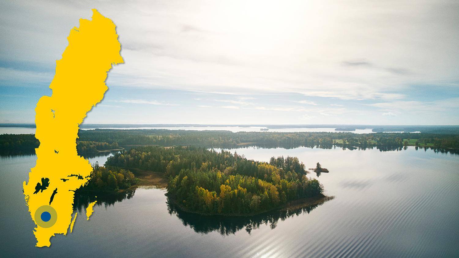 Vue aérienne du lac de Bolmen et de ses îles. Il y a une carte jaune de la Suède avec un point bleu qui indique l'emplacement du lac Bolmen.