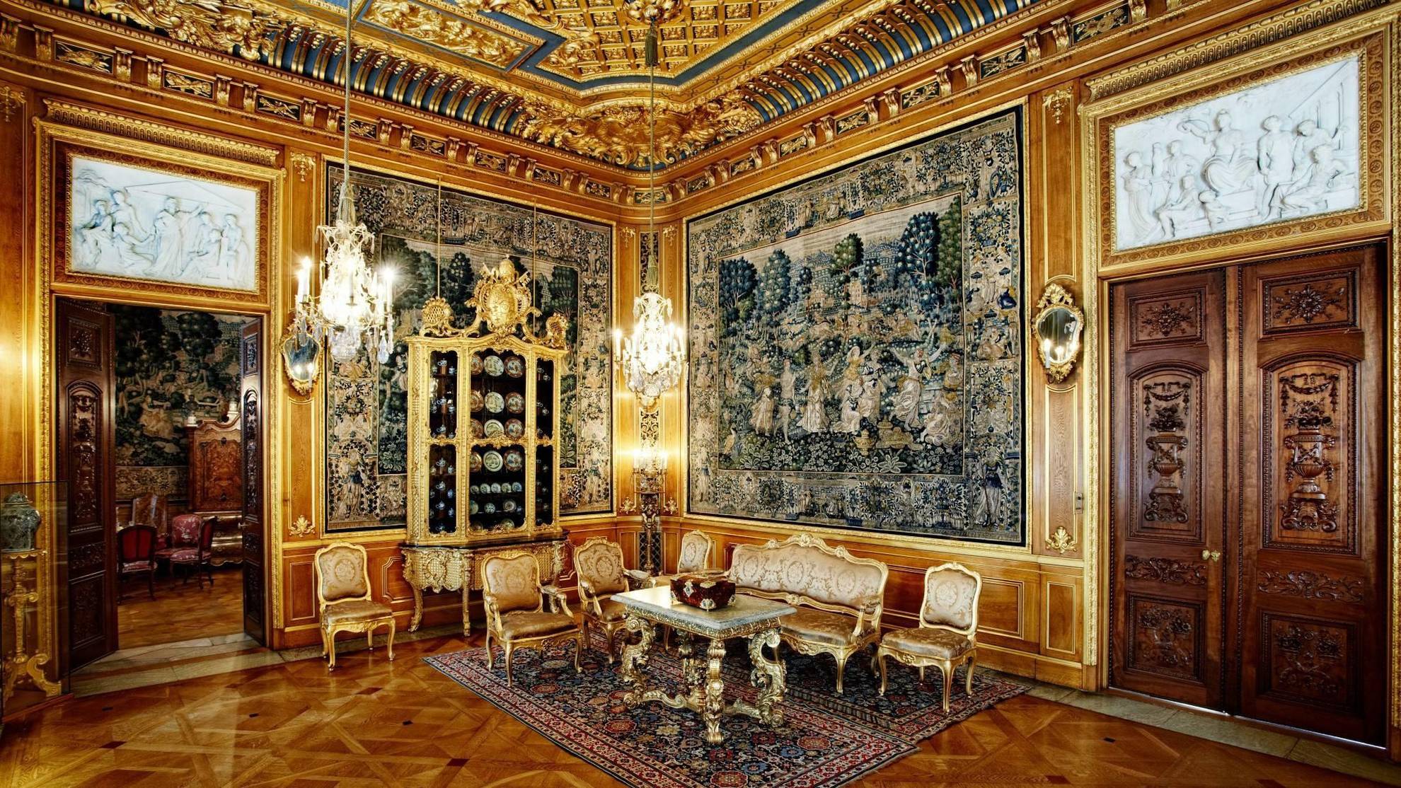 Le luxueux salon doré de la maison Hallwyl comporte de grands tableaux, des meubles dorés et des lustres.