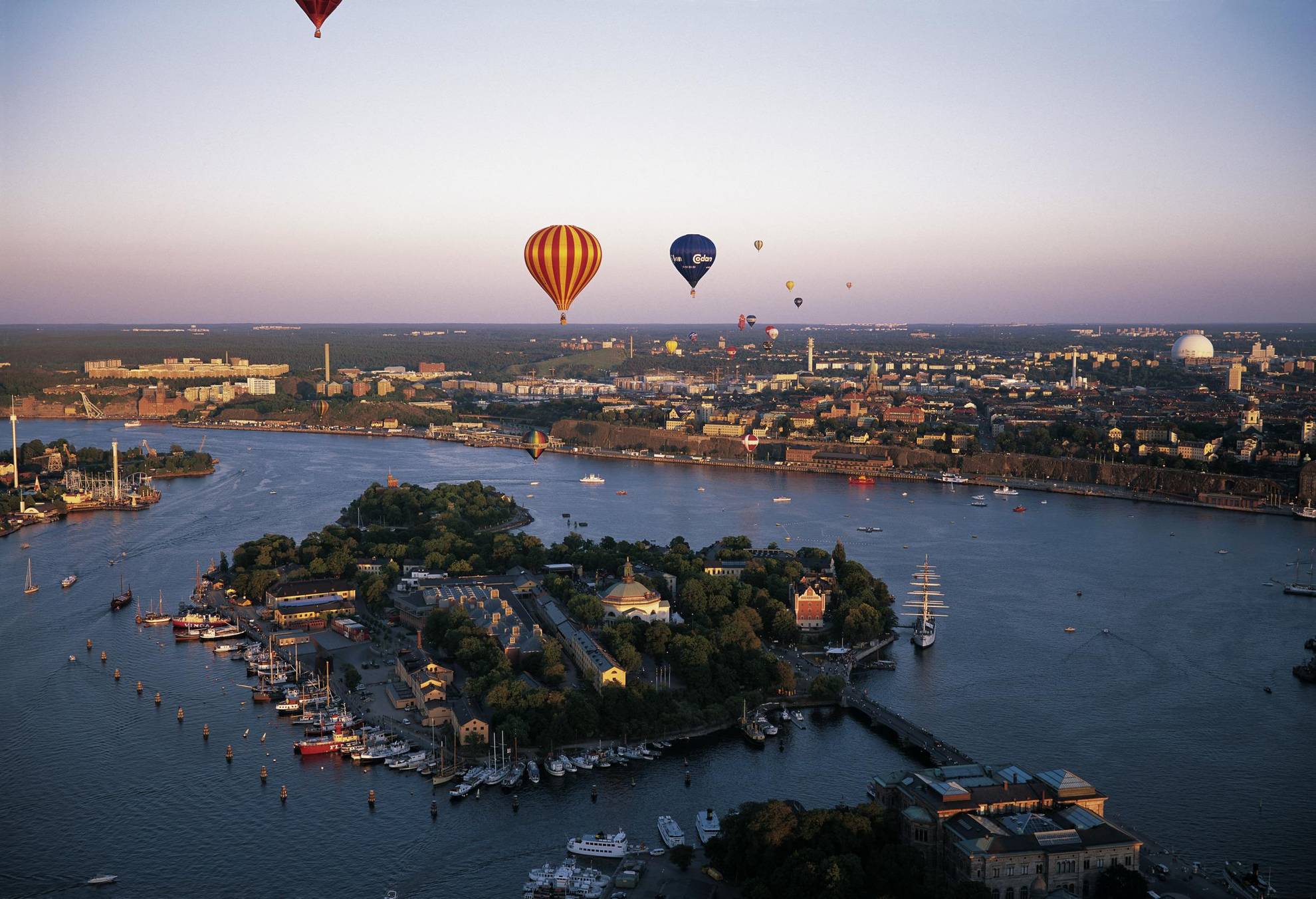 Des montgolfières de différentes couleurs volent au-dessus de Stockholm lors d'une soirée d'été.