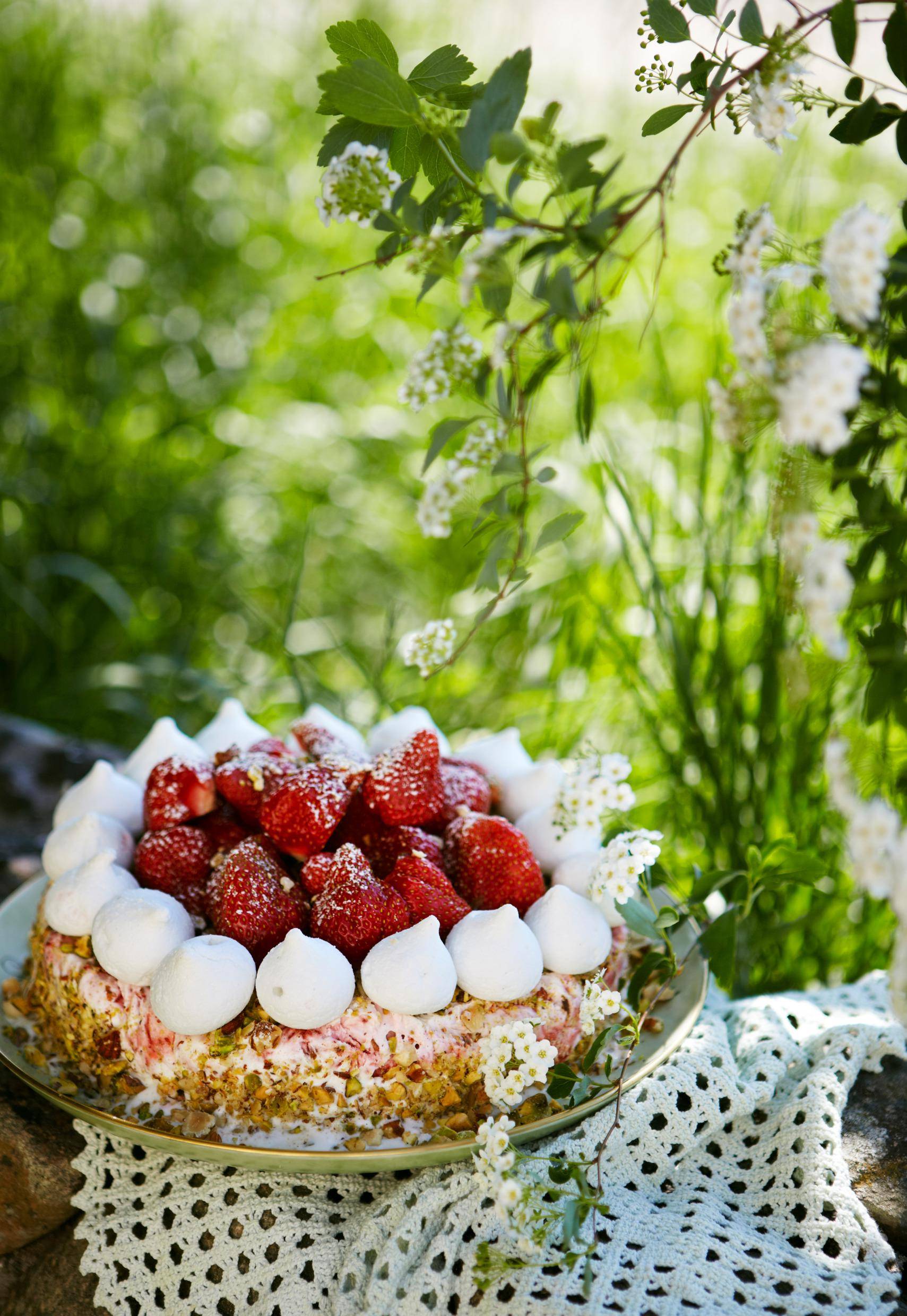 Un gâteau aux fraises est posé sur un chariot avec la nature en arrière-plan.