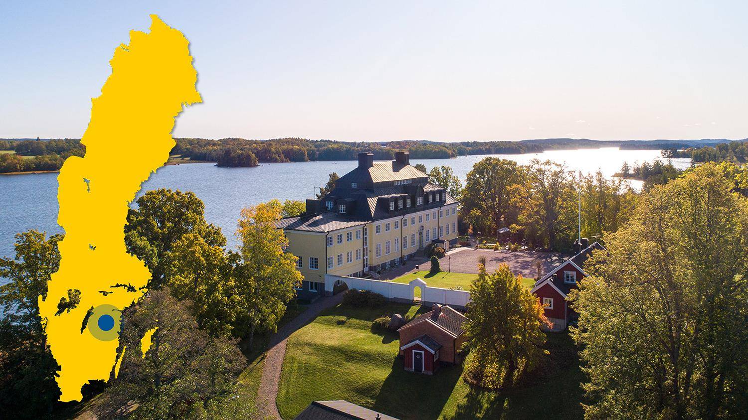 A manor with a yellow facade is located on a hill overlooking the water. In the picture is a yellow map of Sweden with a mark that shows Rimforsa.
