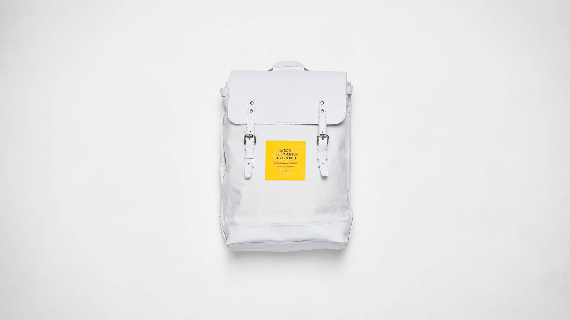 Un sac à dos blanc avec un autocollant jaune dessus.