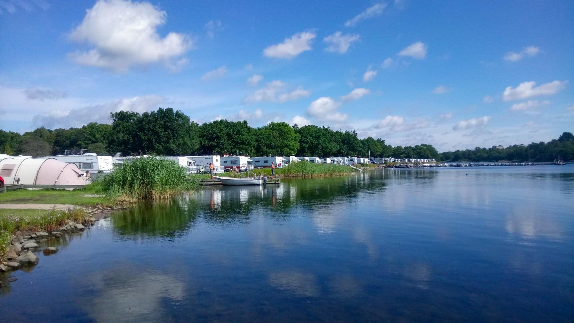 Les caravanes et les tentes sont alignées au bord de l'eau au Dragsö Camping.