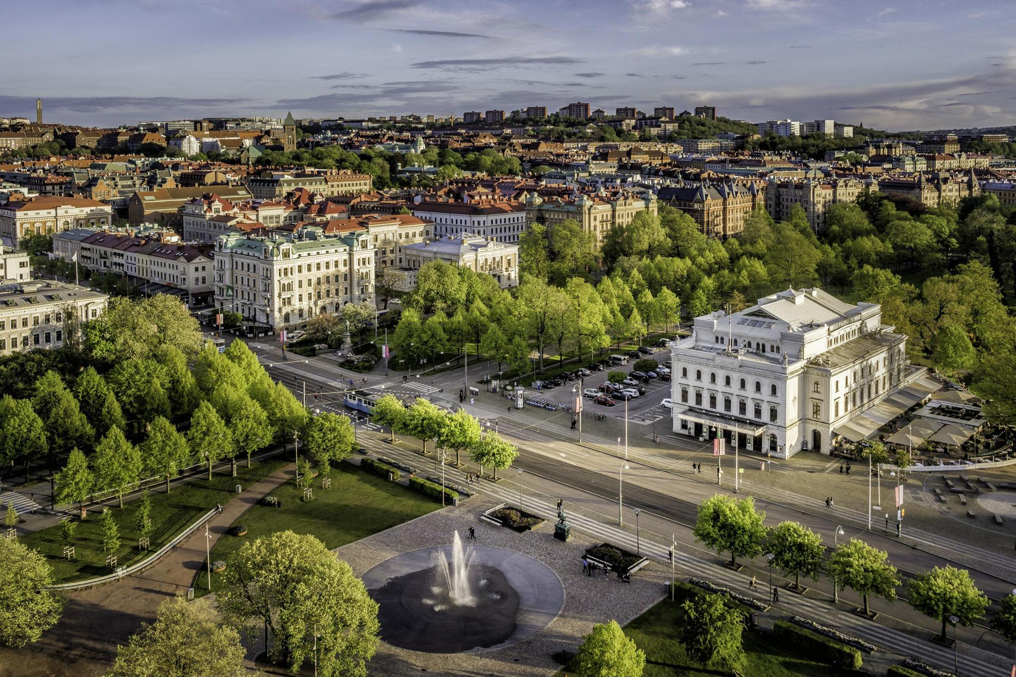 The Gothenburg skyline with streets, large buildings and a park with a fountain.