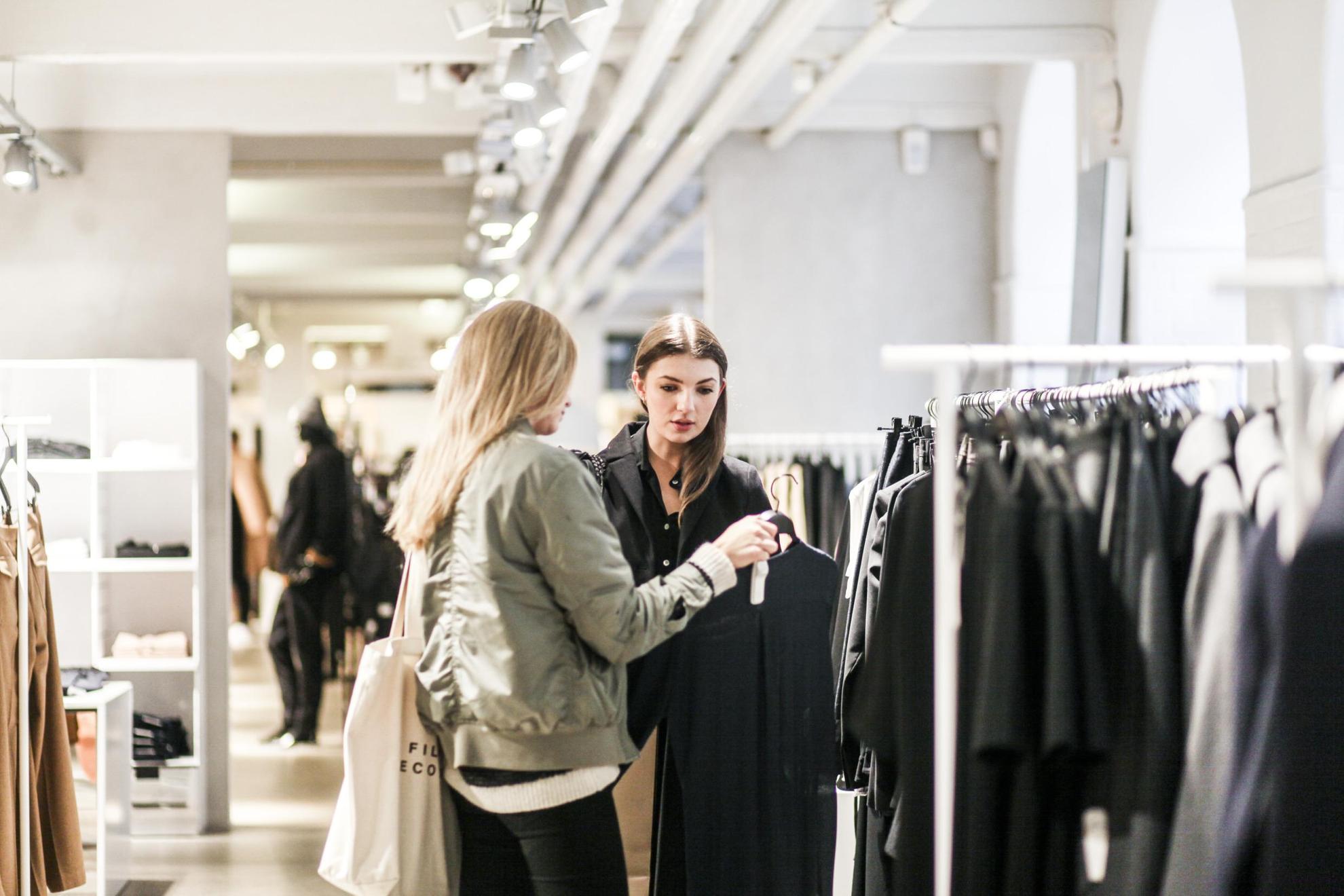 Deux femmes dans un magasin de Stockholm regardant une robe.