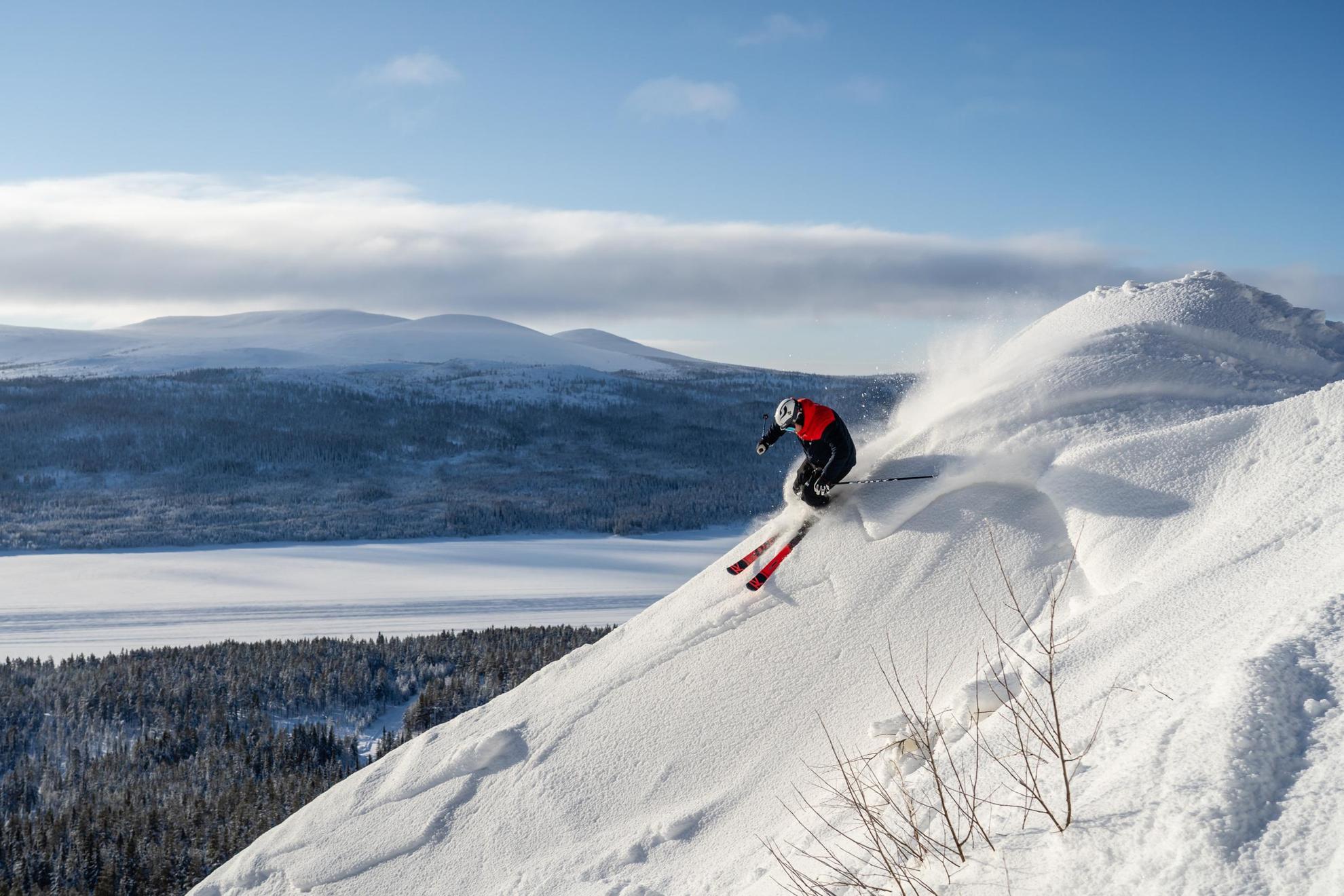 Une personne skiant sur la montagne avec une vue sur un paysage enneigé en arrière-plan.