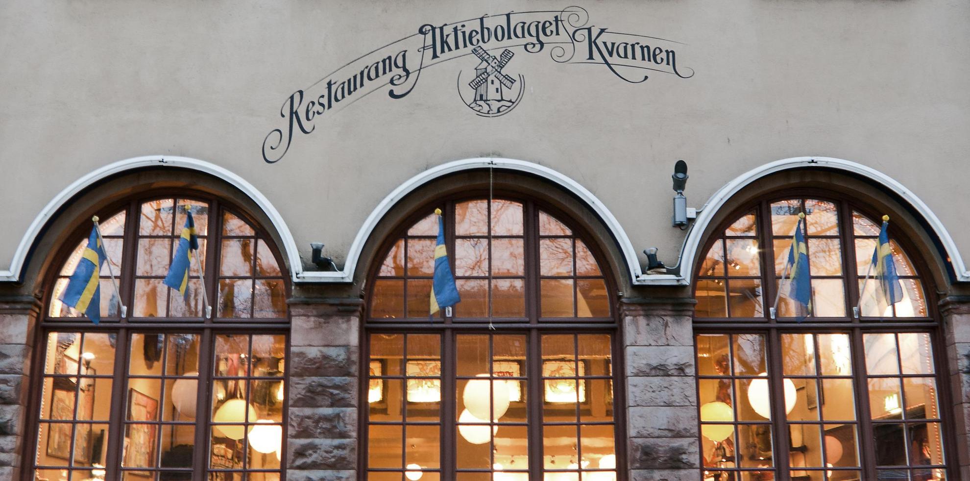 The exterior of restaurant Kvarnen in Stockholm, with domed windows and Swedish flags.