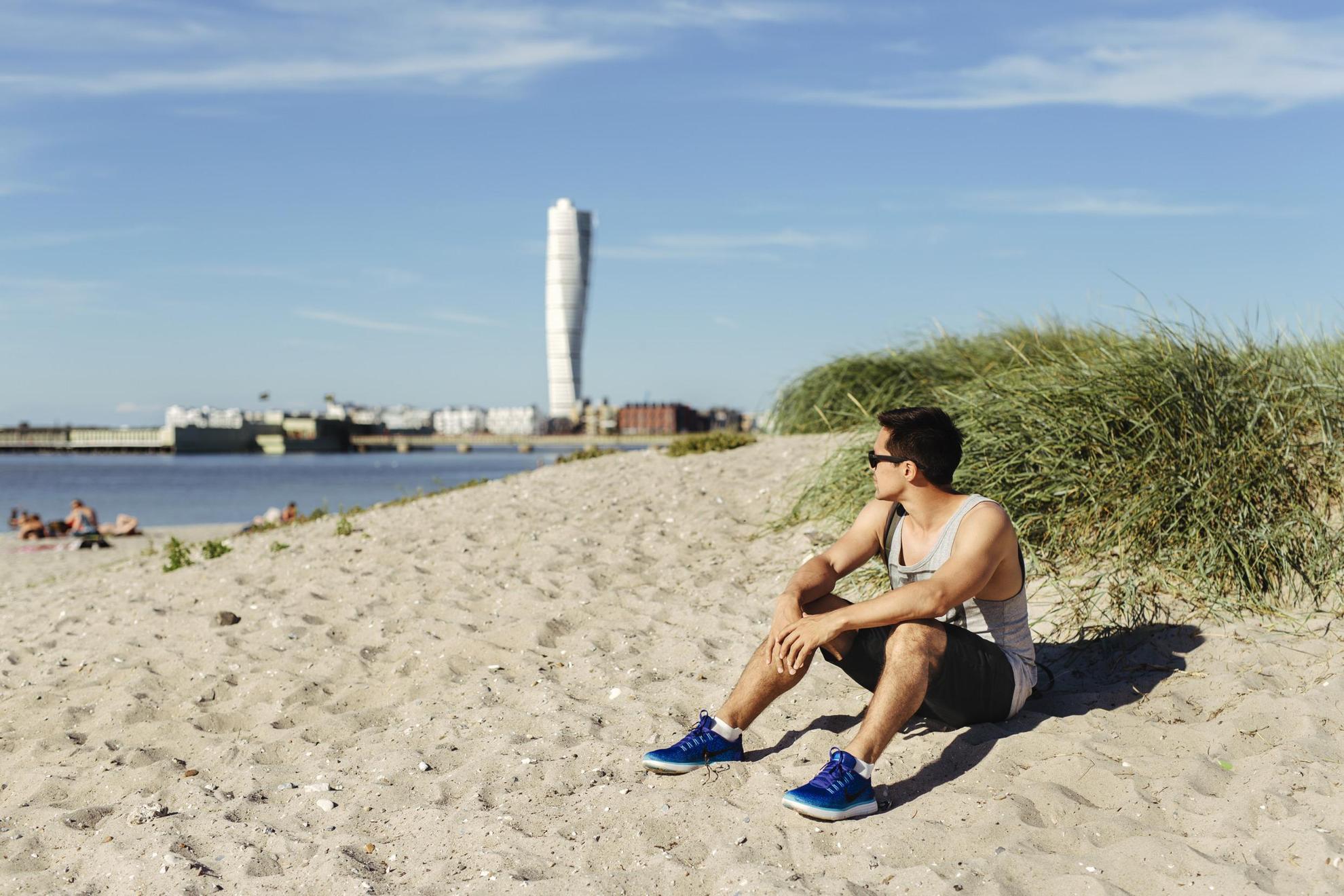 Un homme profitant du soleil sur la plage de Ribersborg à Malmö