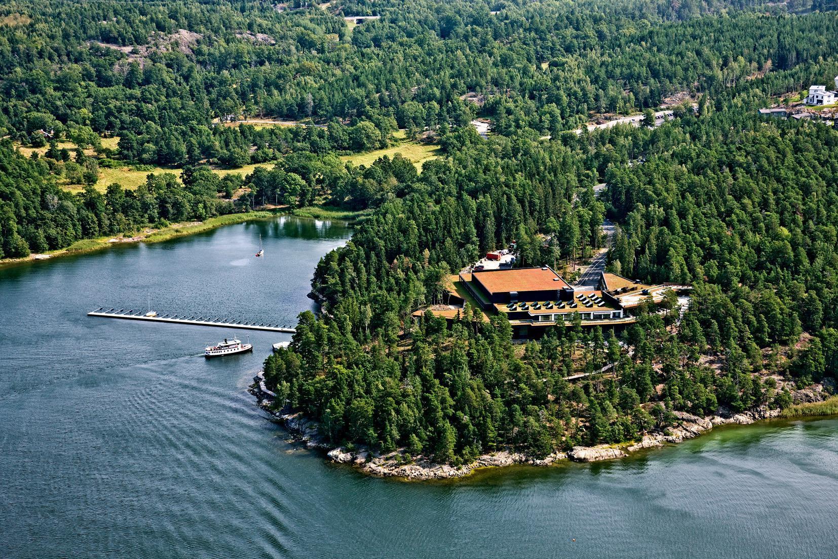 Vue aérienne du centre culturel Artipelag dans l'archipel de Stockholm. Le bâtiment est entouré de forêt et de l'archipel.