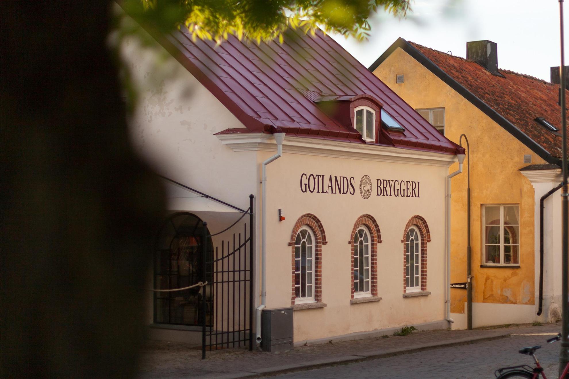 Une rue avec une maison blanche. Sur la maison, il est écrit "Gotlands Bryggeri".