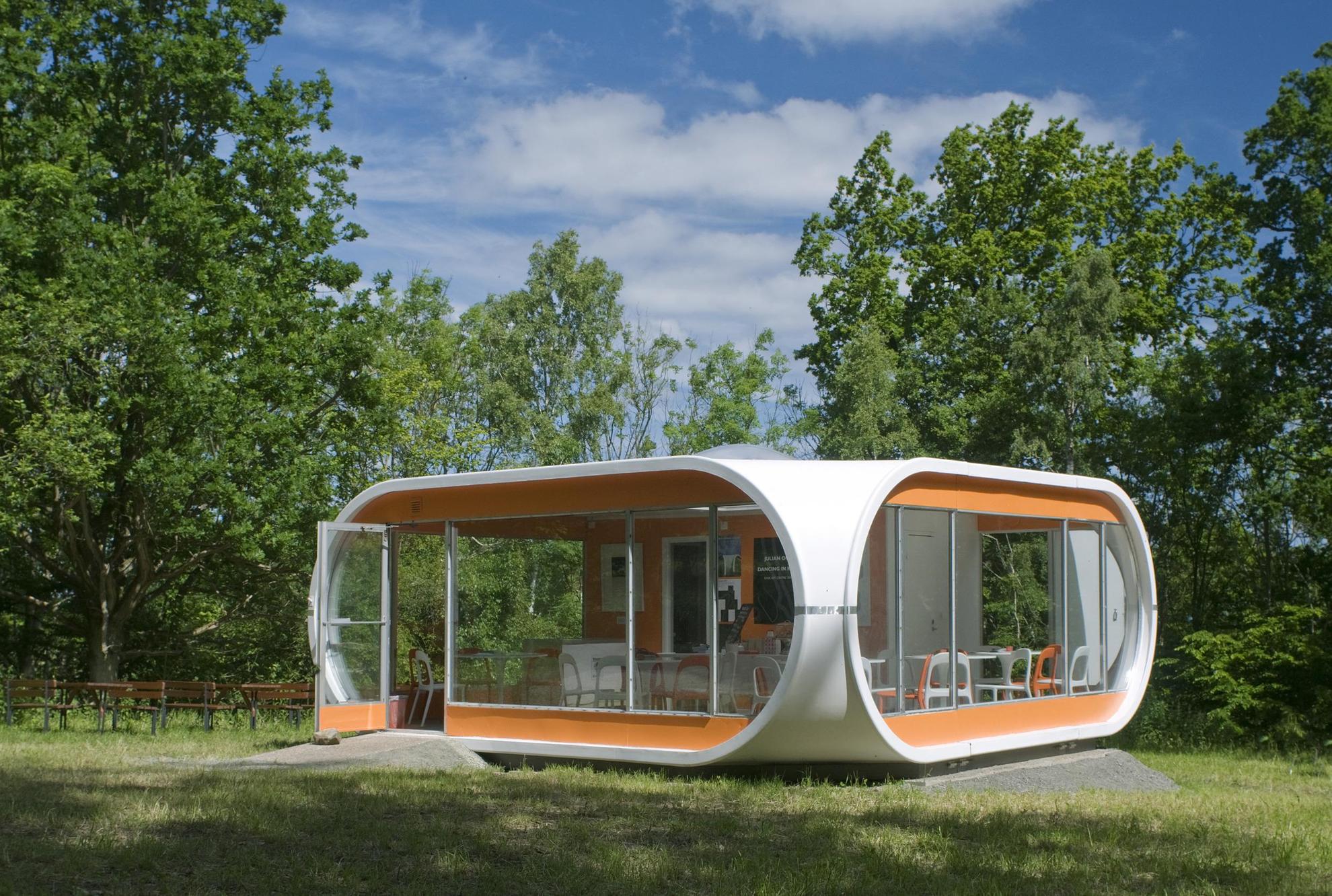 Petit logement en plastique orange et blanc situé dans un espace de verdure dans le Centre d'Art de Kivik